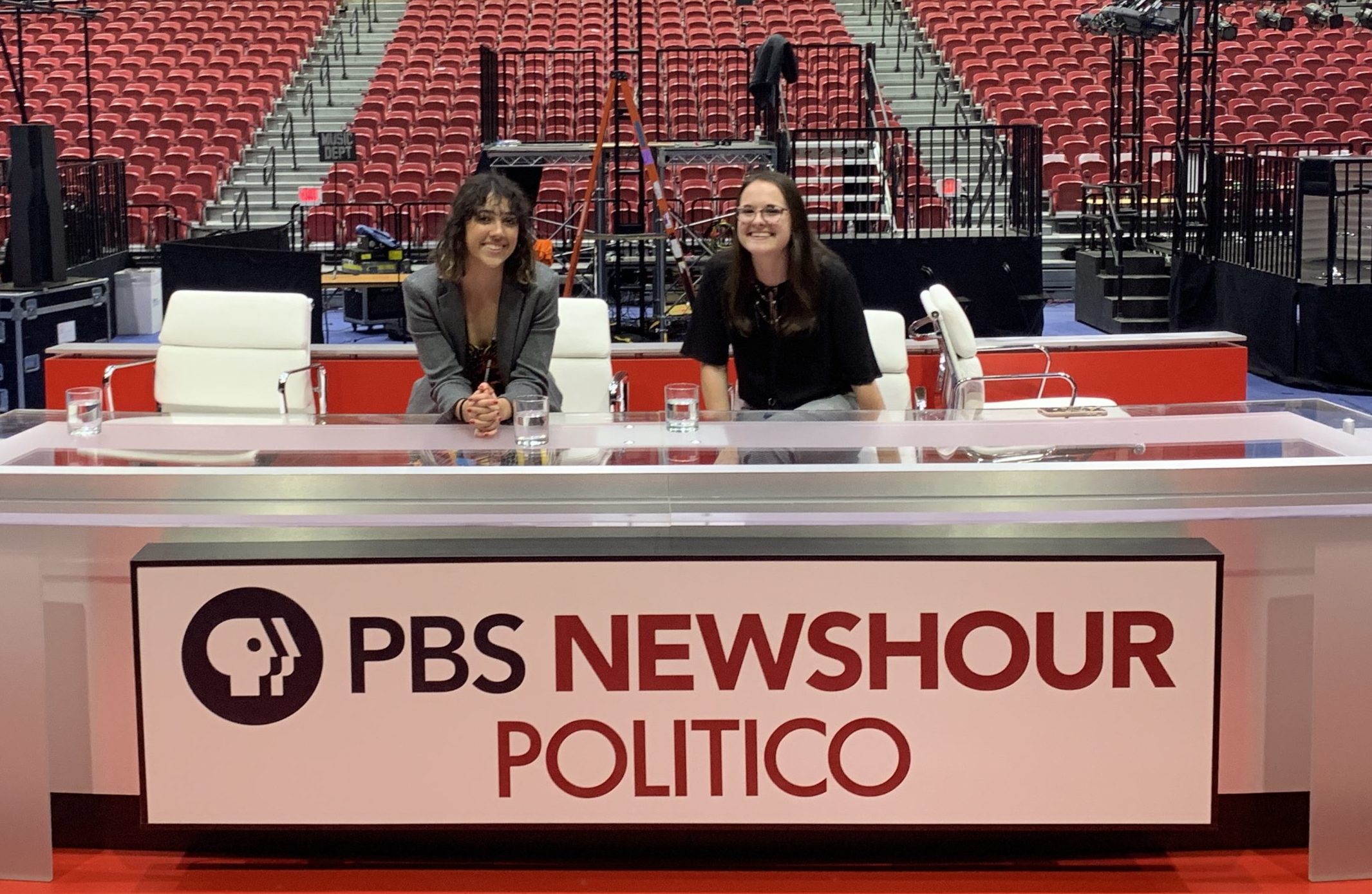 Two female students standing at the PBS Newshour Desk during the December 2020 debate.